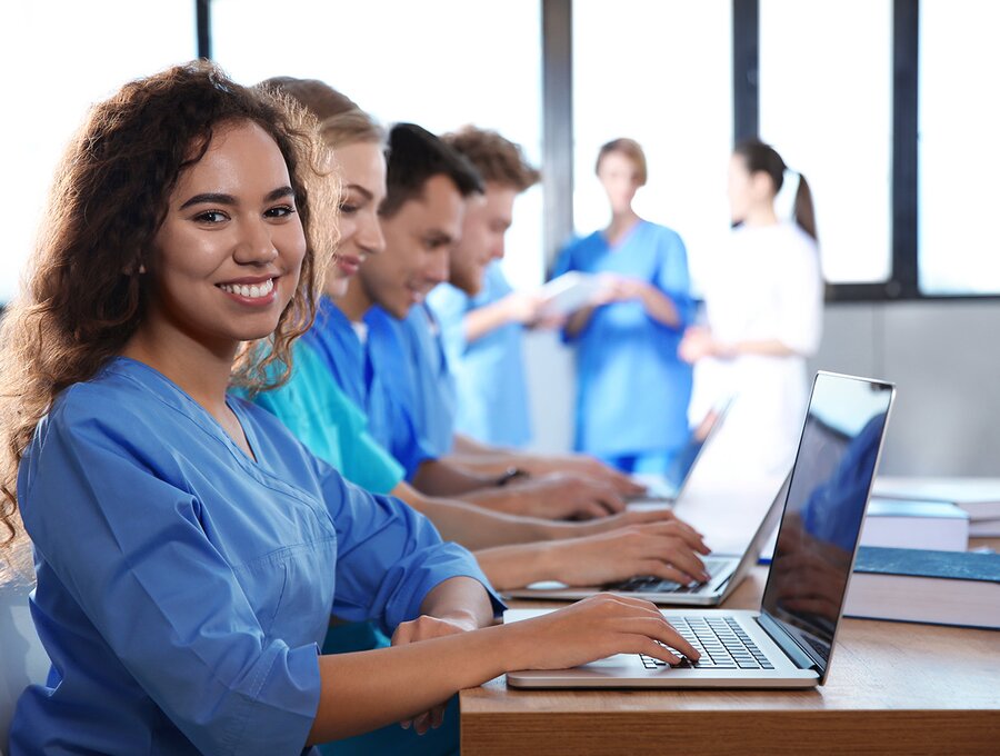Eine Gruppe von Angehörigen der Gesundheitsberufe sitzt vor einem Computer und führt Schulungsmaßnahmen durch.