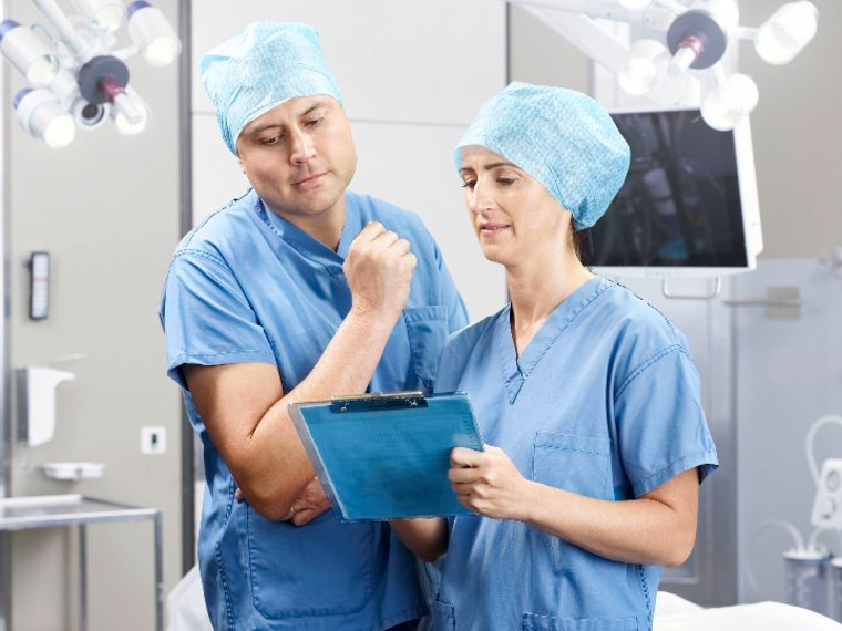A doctor and nurse discuss medical treatment in an operating room.