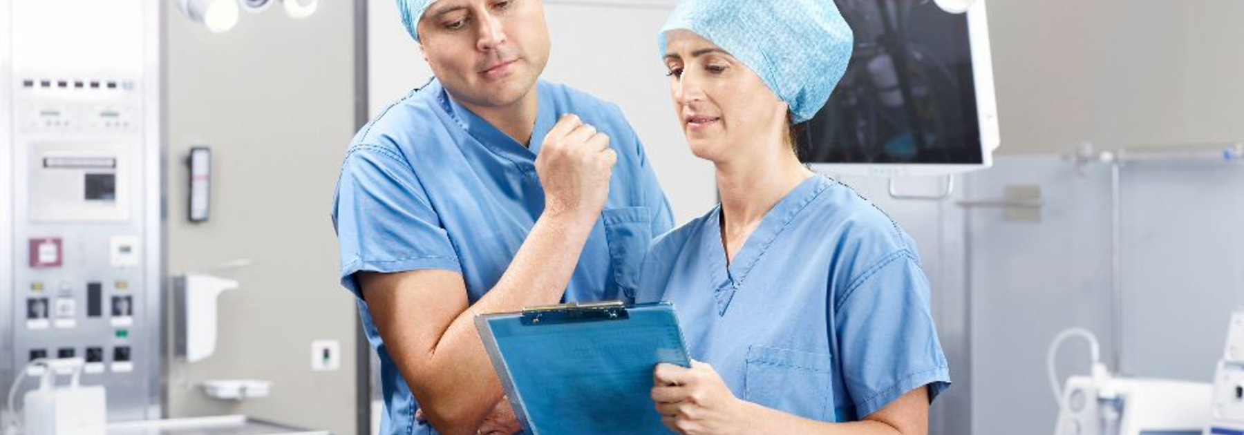 Um médico e uma enfermeira discutem um tratamento médico num bloco operatório.