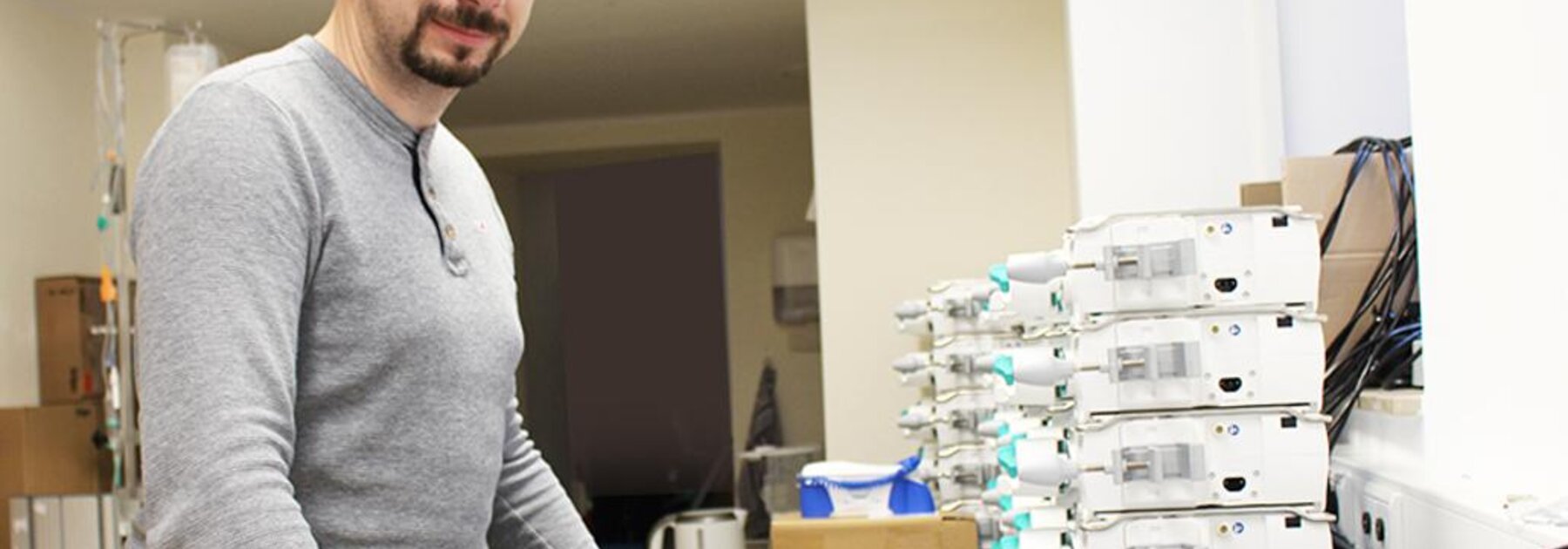 Foto von Dr. Robert Schmidt, der über medizinischen Geräten steht