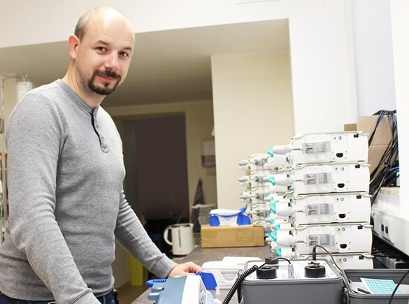 Foto von Dr. Robert Schmidt, der über medizinischen Geräten steht