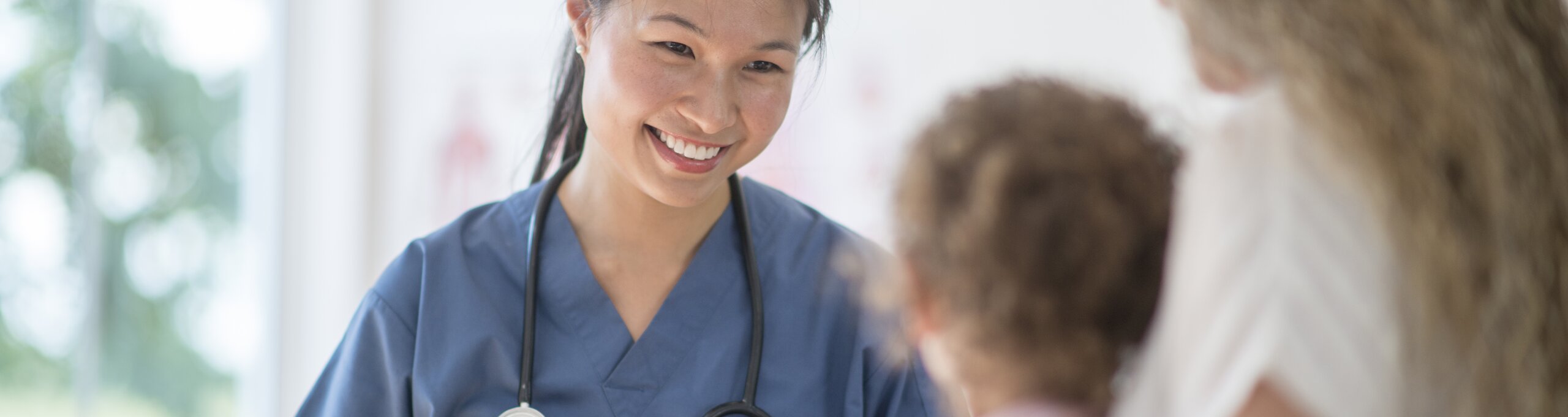 Infirmière souriant à une femme tenant un bébé