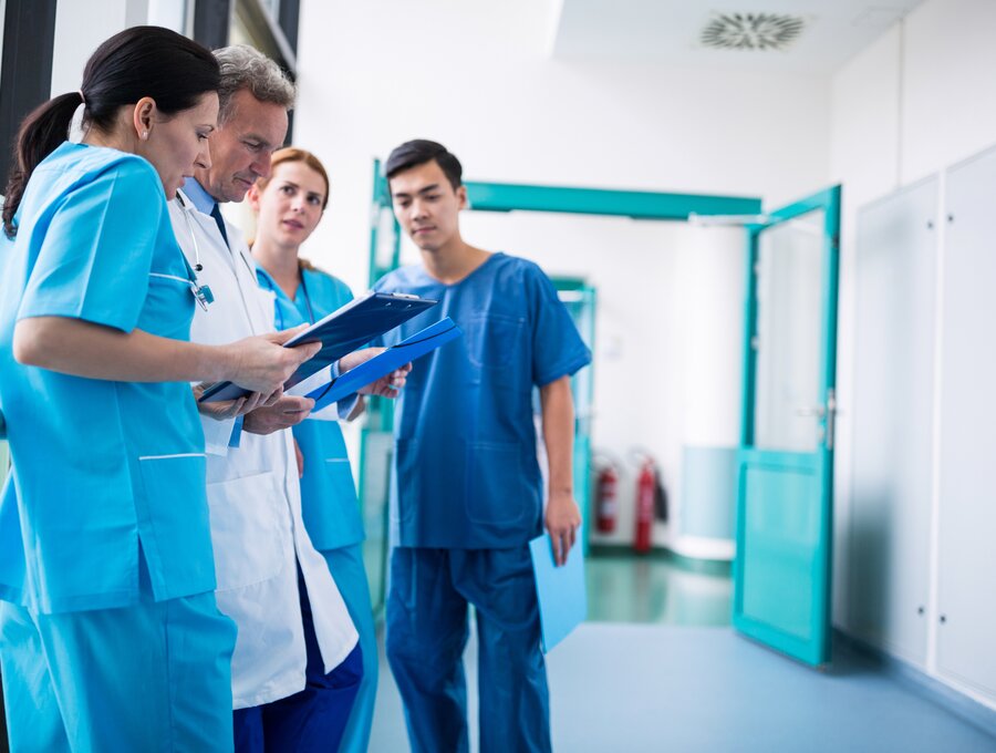 Medizinisches Personal in einem Krankenhaus im Gespräch auf dem Flur.