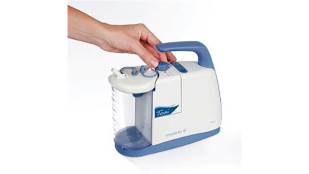 A hand adjusting the vacuum setting on a Medela Clario Toni Pediatric Airway Suction Pump.