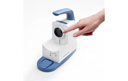 A hand pointing to the membrane of the Medela Clario Airway Suction Pump.