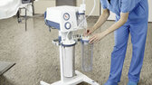 A healthcare professional sets up a Medela Dominant Flex surgical suction pump with a reusable canister in a hospital.