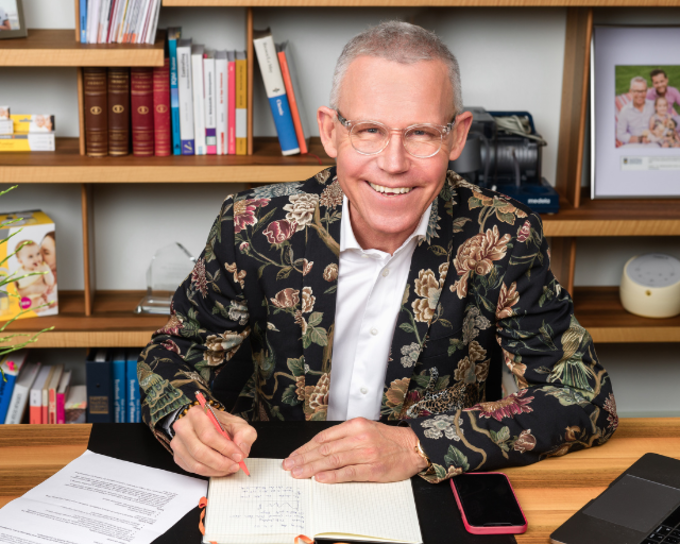 Photo of Michael Larsson signing a document while sitting at a desk.
