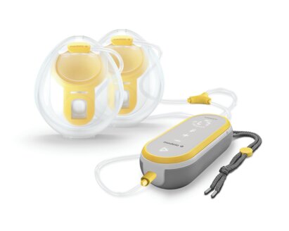 Pompe mains libres Medela Freestyle présentée avec les bonnets de recueil mains libres.