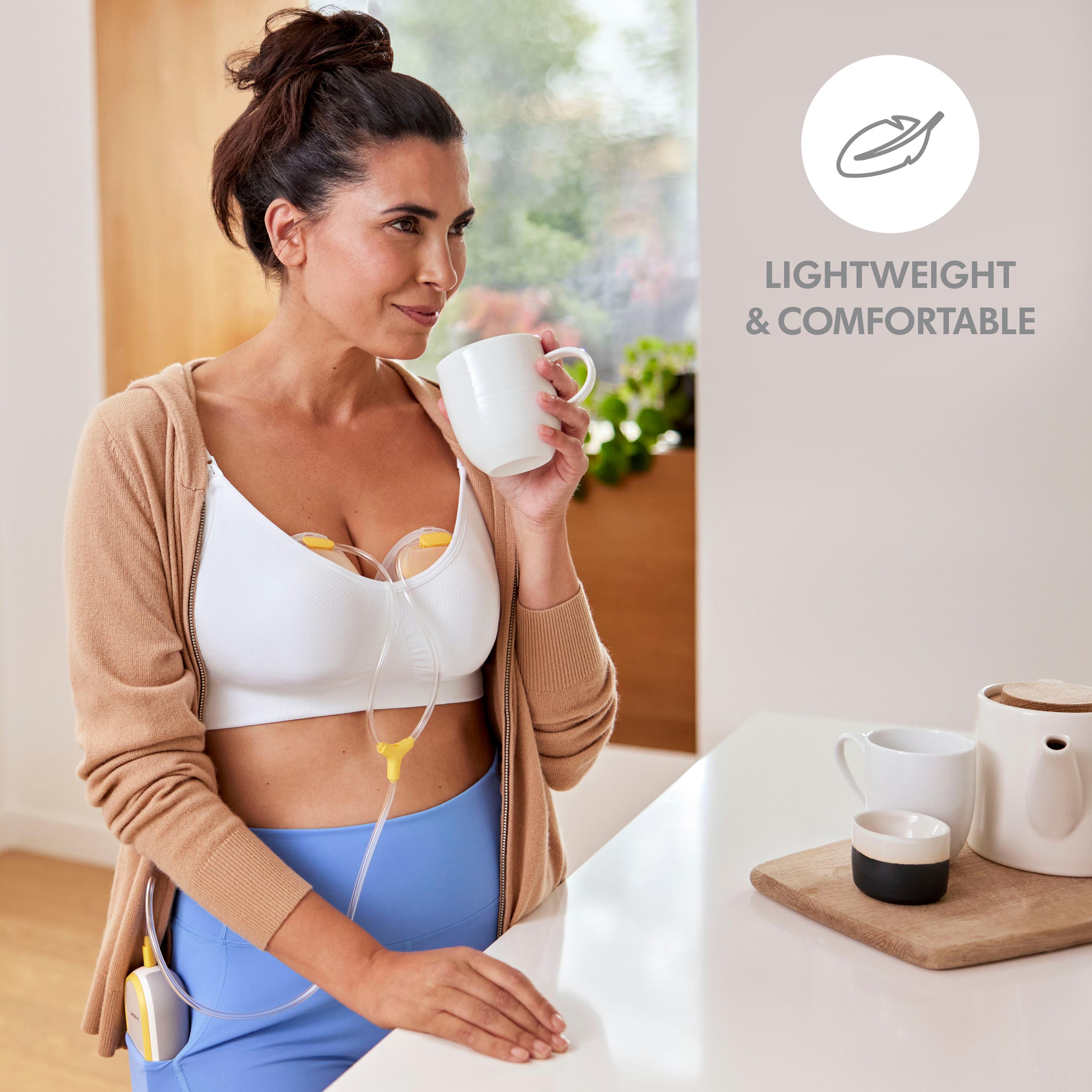 Mom drinking coffee while wearing her Medela Freestyle™ Hands-free double electric wearable breast pump. Image text says, "Lightweight and comfortable."