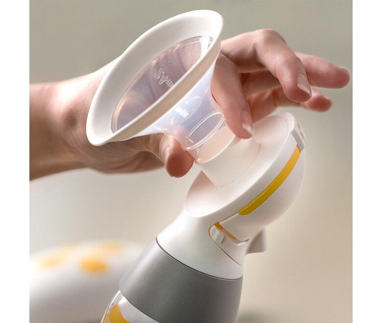 Le mani di una persona mostrano come attaccare e rimuovere la protezione per il seno Medela PersonalFit Flex™.
