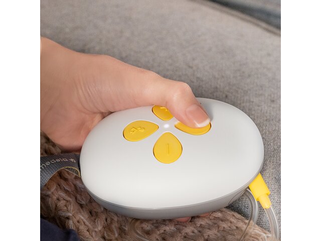 A woman changes the settings on her Medela Swing Maxi™ Hands-free breast pump.