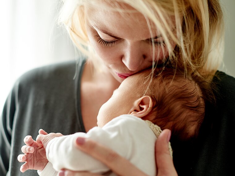 baby being burped to reduce spit-up, with helpful tips and insights from Medela