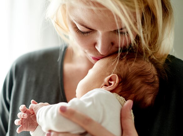 baby being burped to reduce spit-up, with helpful tips and insights from Medela