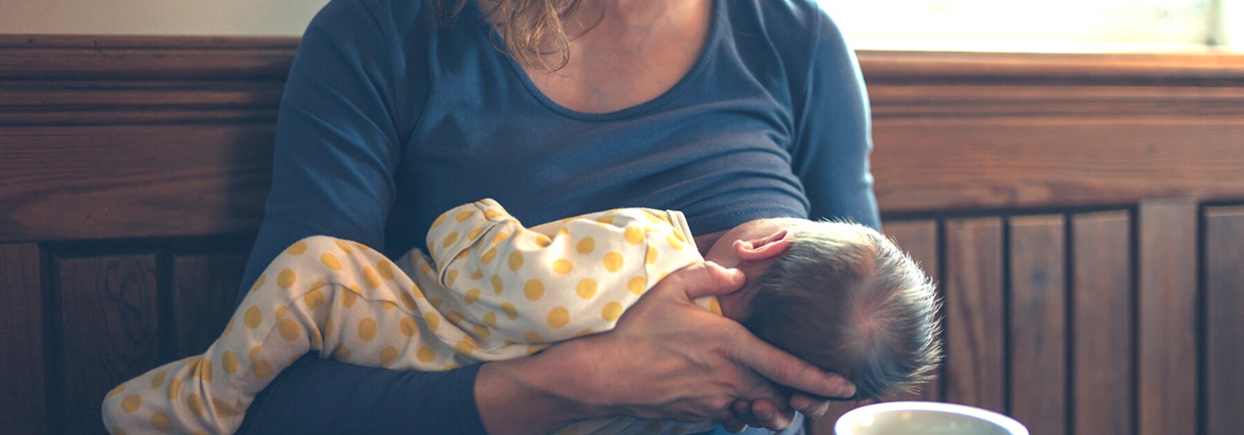 A mother breastfeeds her baby in public.