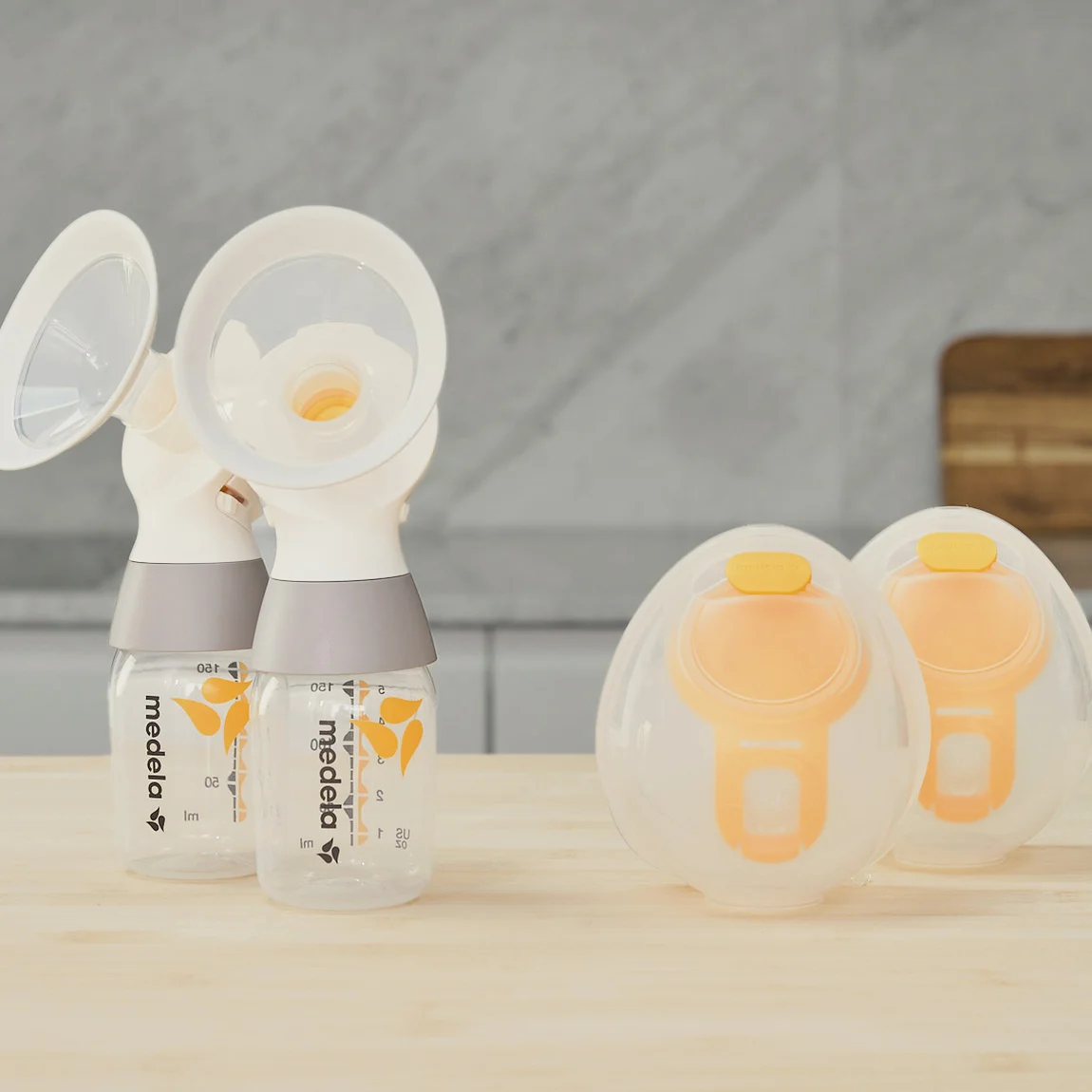 Een set Medela Hands-free opvangbekers met een Medela klassieke PersonalFit Flex™ dubbele kolfset, tubes niet afgebeeld, zittend op een aanrecht.