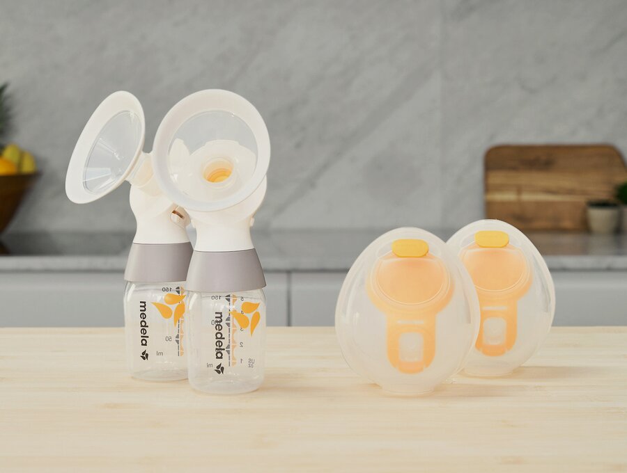 A set of Medela Hands-free Collection Cups with a Medela classic PersonalFit Flex™ double pumping kit, tubes not shown, sitting on a counter.