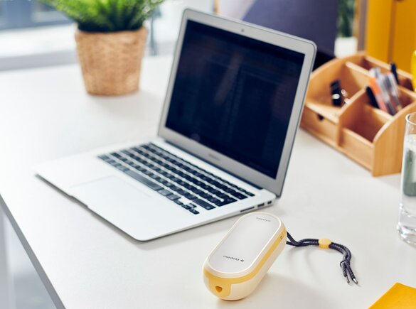 A Freestyle Flex™ double electric 2-phase breast pump on the desk next to a laptop.