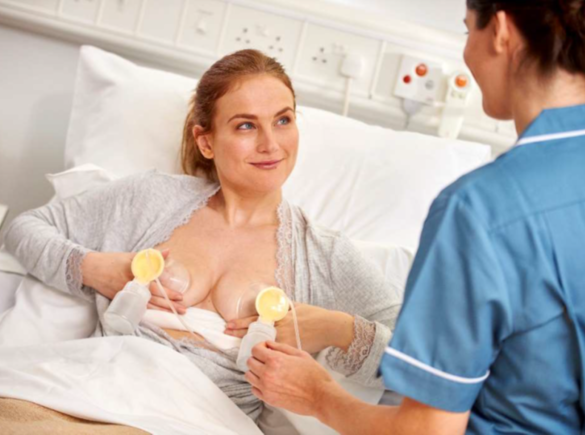 Eine Frau erhält von einer medizinischen Fachkraft im Krankenhaus Ratschläge zum Abpumpen.