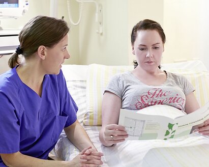 Eine Krankenschwester gibt einer Mutter Informationen über Mastitis.