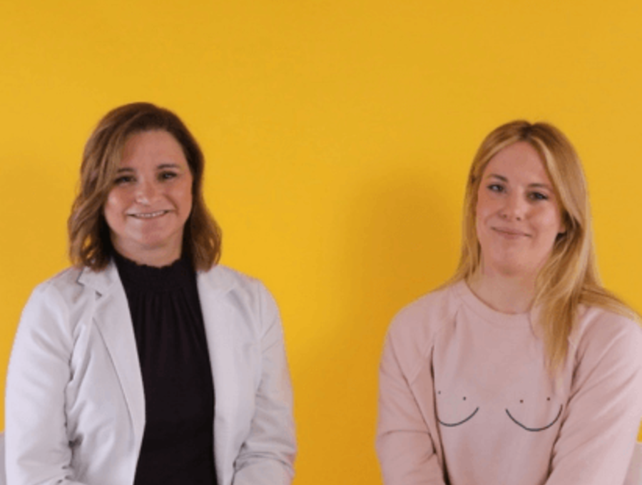 Two female lactation professionals sitting against a yellow backdrop.